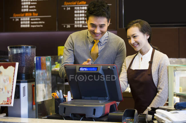 Китайський кави магазин крамар і офіціантка, використовуючи касовий апарат — стокове фото