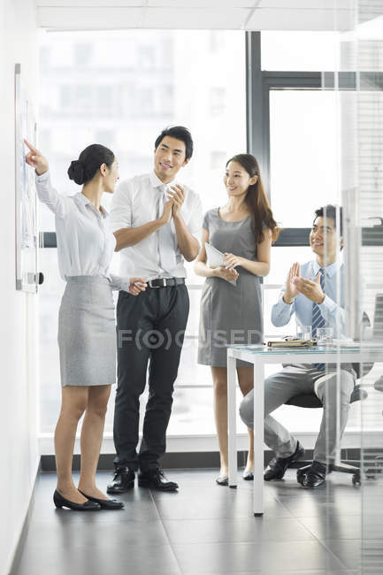 Negócios chineses falando em reunião na sala de bordo — Fotografia de Stock