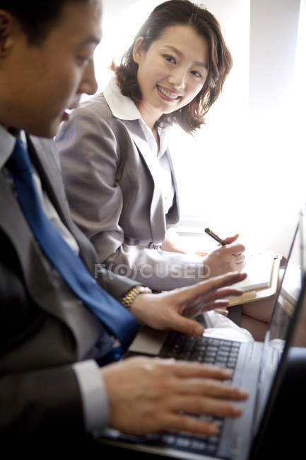Uomini d'affari cinesi che lavorano con laptop in aereo — Foto stock