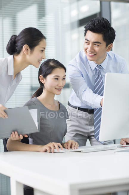 Equipo empresarial chino que utiliza el ordenador en la oficina - foto de stock
