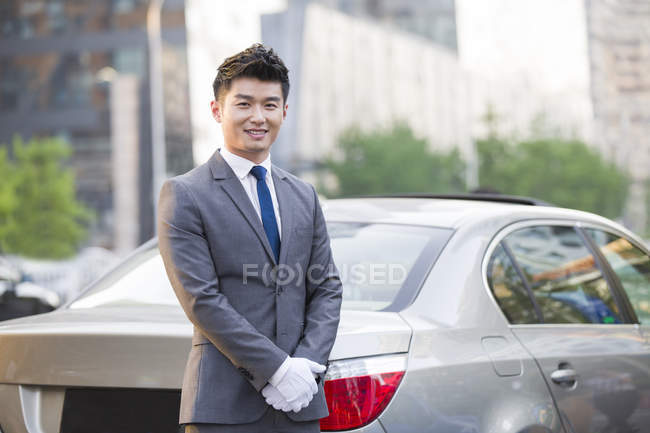 Китайский шофер стоит перед машиной — стоковое фото