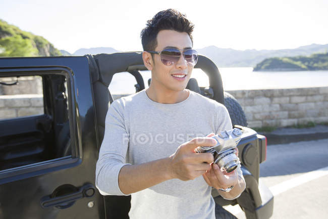 Chinese man taking photos in suburbs — Stock Photo