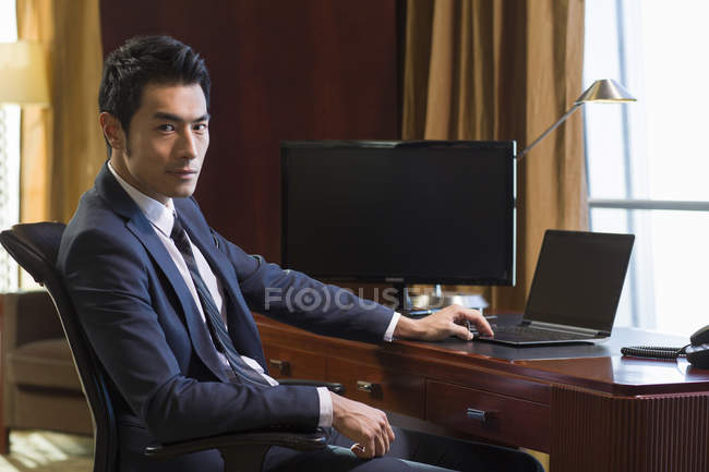 Retrato de empresário chinês na mesa no escritório em casa — Fotografia de Stock