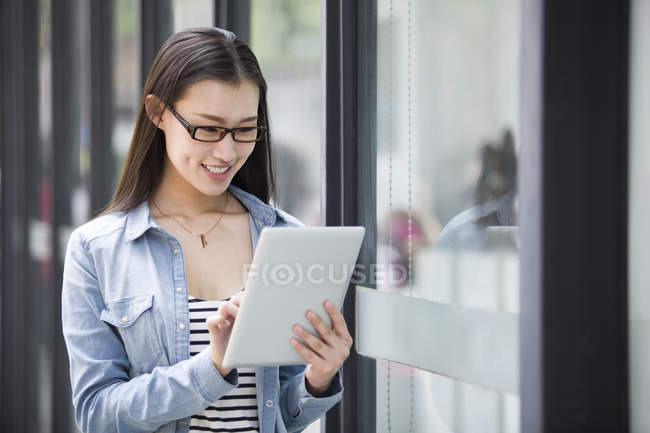 Chinese woman using digital tablet on street — Stock Photo