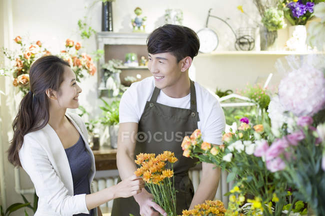 Floristería china y cliente en floristería - foto de stock