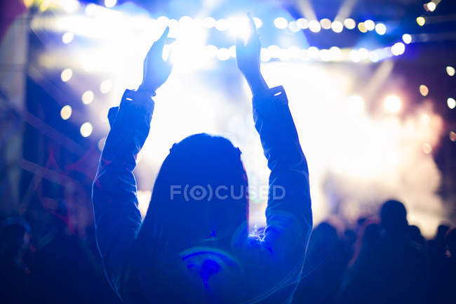 Femme aux bras levés au festival de musique — Photo de stock