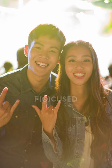 Chinese couple making rock and roll sign at concert — Stock Photo
