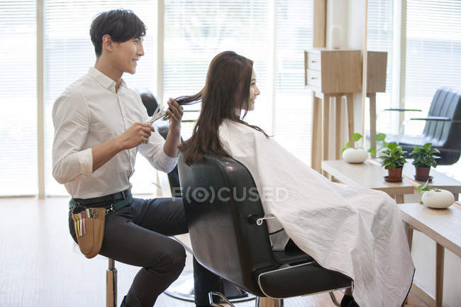 Peluquero chino corte de pelo de cliente femenino - foto de stock