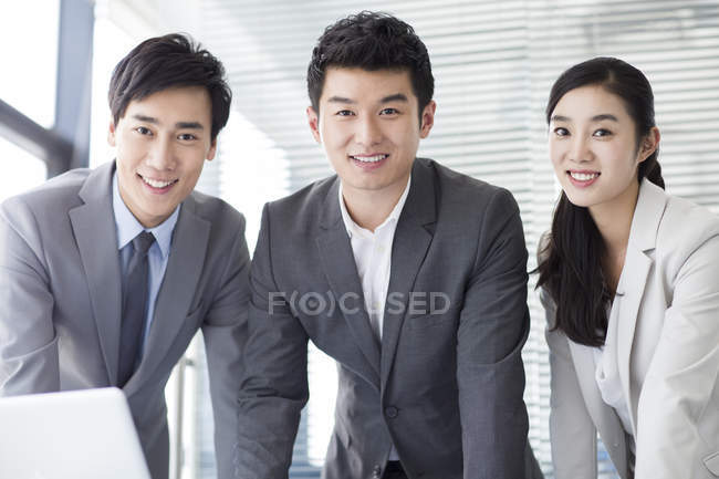 Chinese business people looking in camera in office — Stock Photo