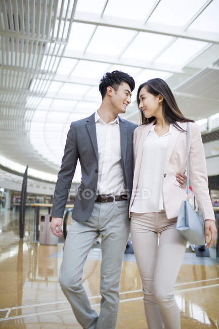 Casal chinês abraçando enquanto caminhava no shopping — Fotografia de Stock