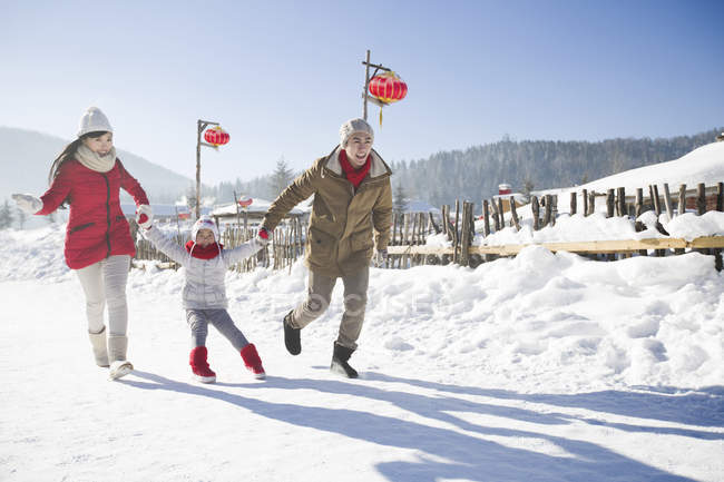 Pais chineses puxando filha na neve — Fotografia de Stock