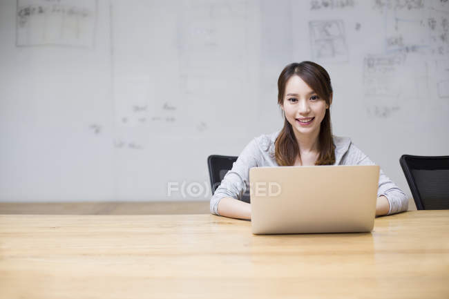 Chinesin sitzt mit Laptop im Sitzungssaal — Stockfoto