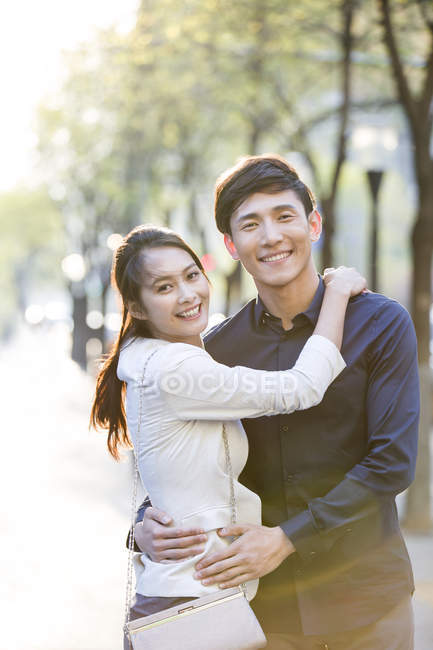 Couple chinois embrassant dans la rue et regardant à la caméra — Photo de stock