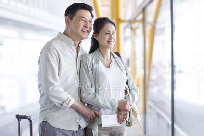 Couple chinois mature debout à l'aéroport avec des billets — Photo de stock