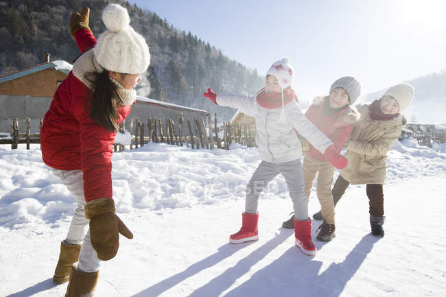Chinesische Kinder im Grundschulalter spielen im Schnee im Dorf — Stockfoto