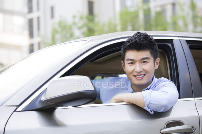 Китайська чоловік, сидячи в машині і дивлячись в камери — стокове фото