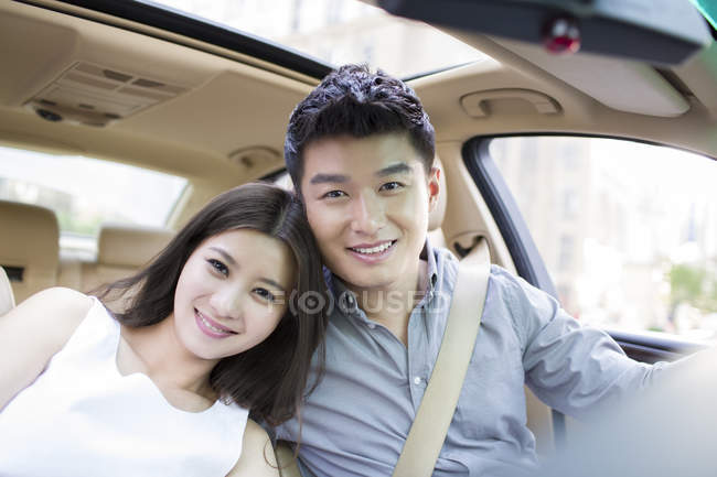 Casal chinês posando juntos no carro — Fotografia de Stock