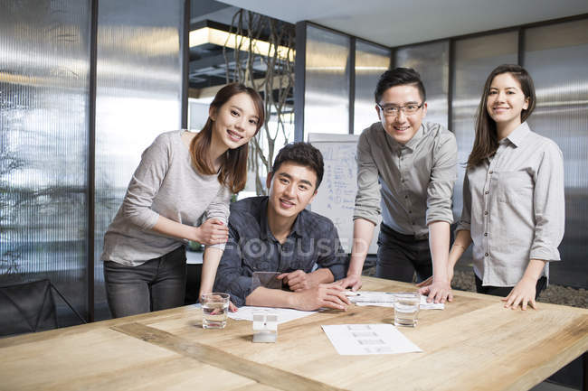 Équipe de travailleurs informatiques chinois posant au bureau — Photo de stock