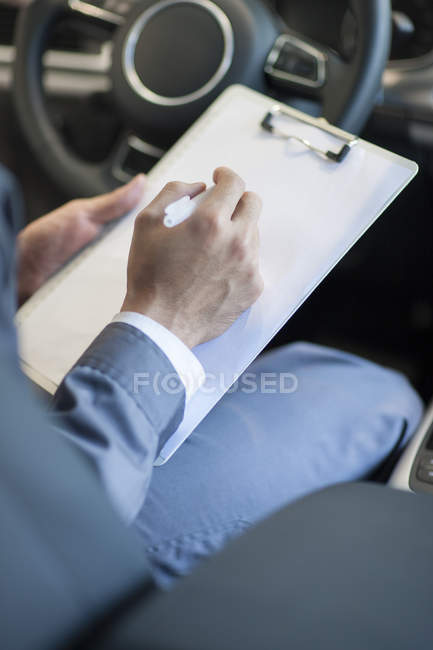 Nahaufnahme eines Automechanikers, der Notizen im Auto macht — Stockfoto