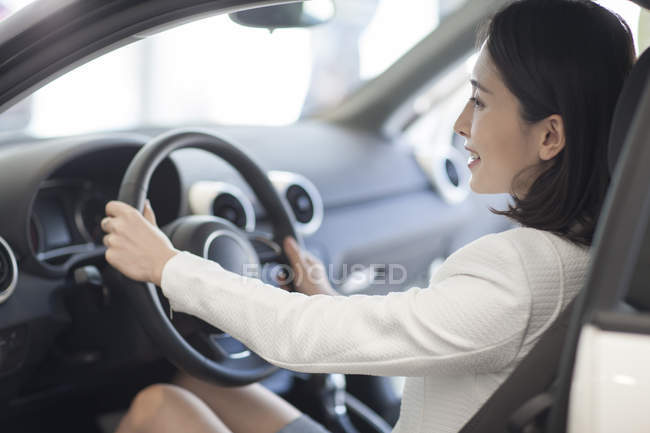 Young chinese woman sitting in car — Stock Photo