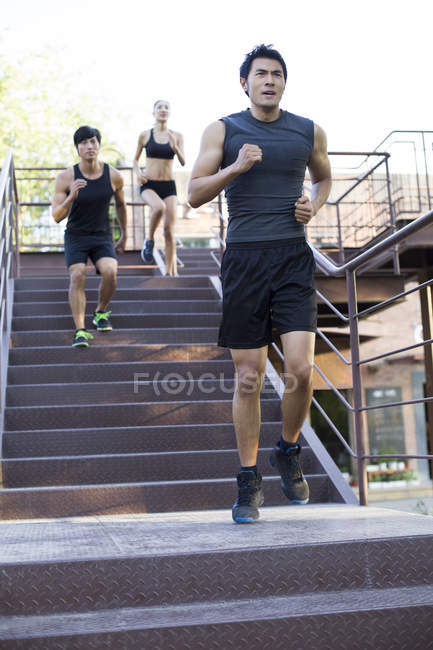 Chinese joggers running down street stairs — Stock Photo