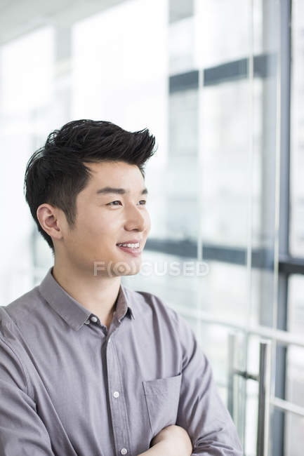 Hombre de negocios chino con los brazos cruzados - foto de stock
