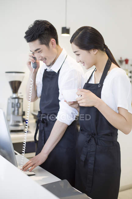 Chinese couple using computer in coffee shop — Stock Photo