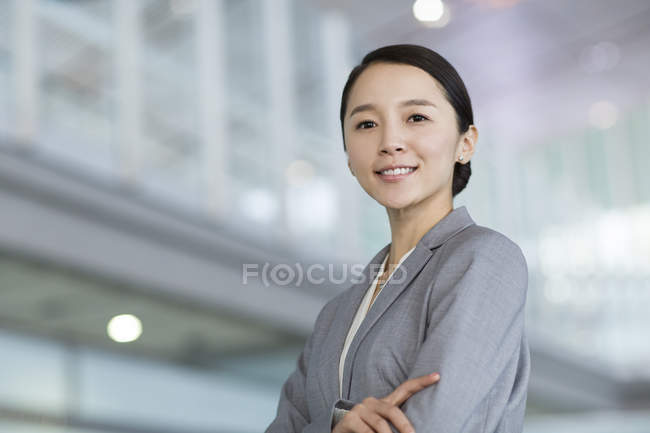 Portrait of Chinese businesswoman standing with arms crossed — Stock Photo