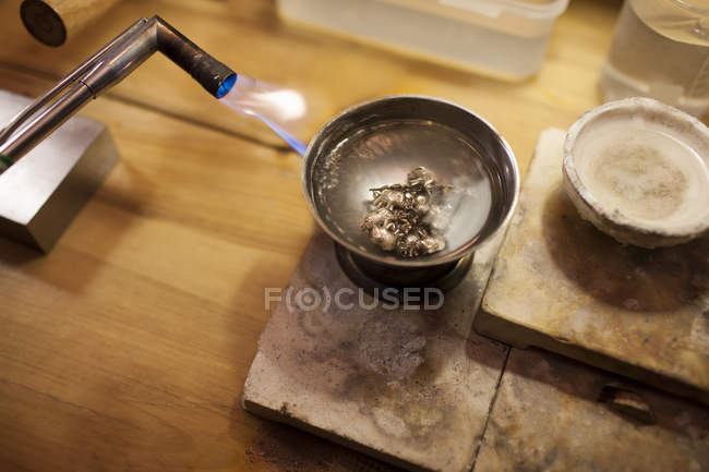 Welding torch melting silver ornaments in jewelry repair shop — Stock Photo