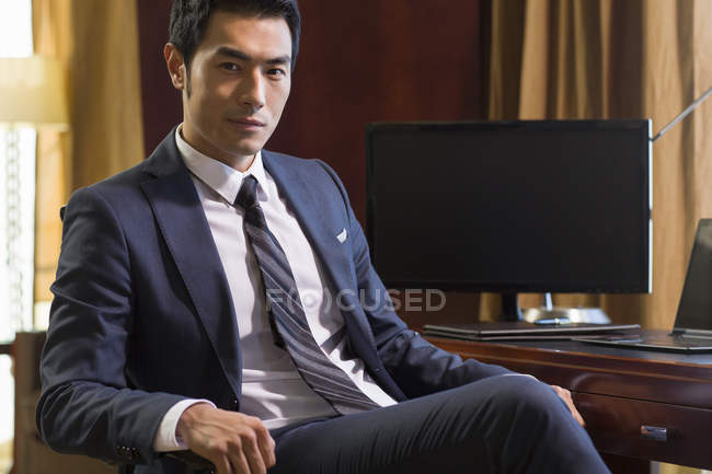 Retrato de hombre de negocios chino en el escritorio en la oficina en casa - foto de stock