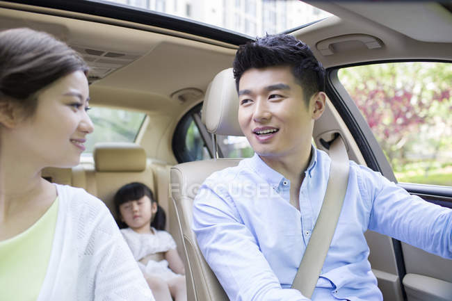 Chinese family riding in car and smiling — Stock Photo