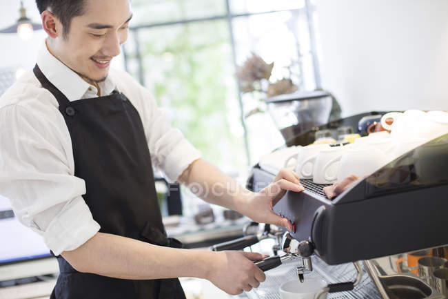 Chinese barista making coffee in cafe — Stock Photo