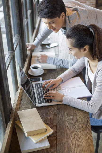 Studenti cinesi che utilizzano il computer portatile in caffè — Foto stock