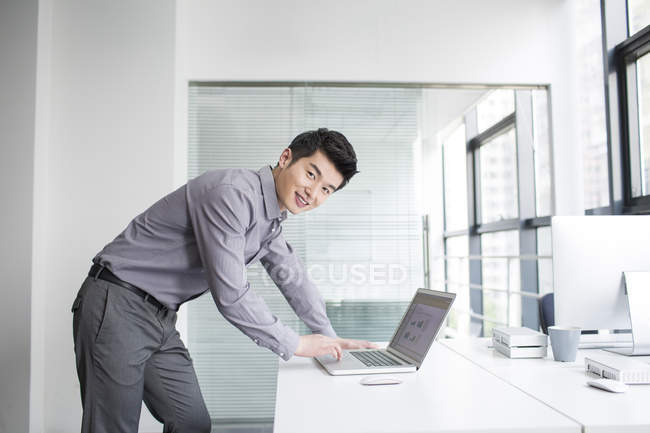 Homme d'affaires chinois utilisant un ordinateur portable dans le bureau — Photo de stock