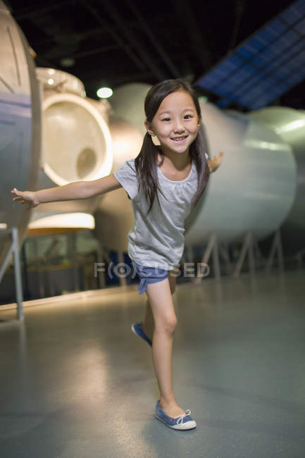 Китаянка позирует с распростертыми в музее руками — стоковое фото
