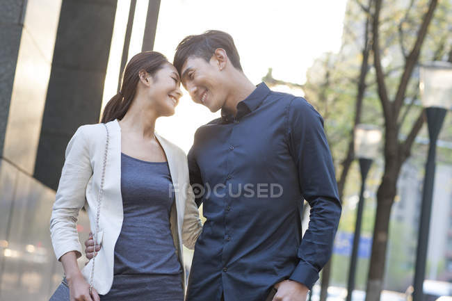 Chinese couple touching foreheads on street — Stock Photo