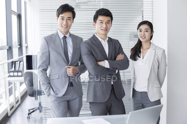 Uomini d'affari cinesi in piedi in sala riunioni — Foto stock