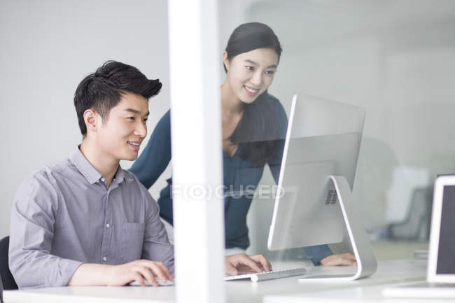 Colaboradores chinos que utilizan la computadora en la oficina - foto de stock