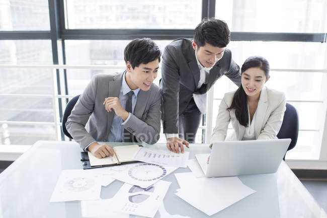 Chinese business people using laptop in meeting room — Stock Photo
