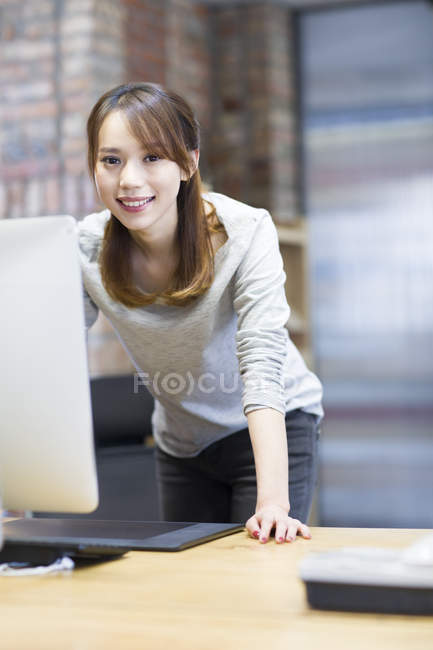 Китайська жінка, що працюють з комп'ютером в офісі — стокове фото