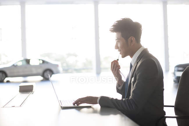 Chinese sale manager with headset using laptop — Stock Photo