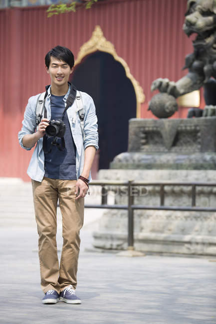 Chinese man visiting Lama Temple with digital camera — Stock Photo