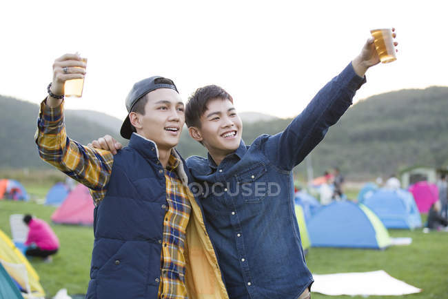 Chinese men posing with beer at festival camping — Stock Photo