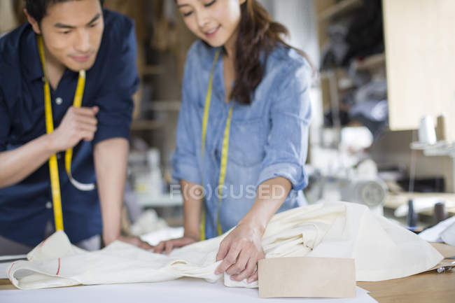 Chinese fashion designers working in studio with textile — Stock Photo
