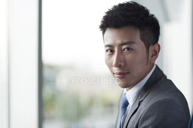 Retrato de hombre de negocios chino mirando en cámara - foto de stock