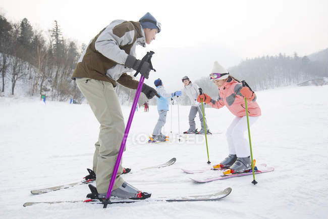 Chinese parents teaching children skiing in ski resort — Stock Photo