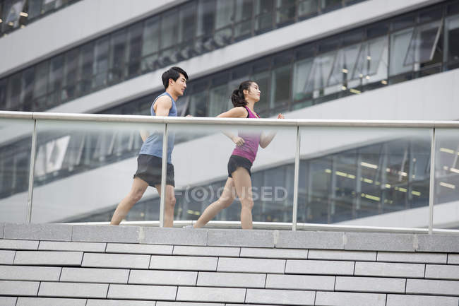China pareja corriendo juntos en pasarela - foto de stock