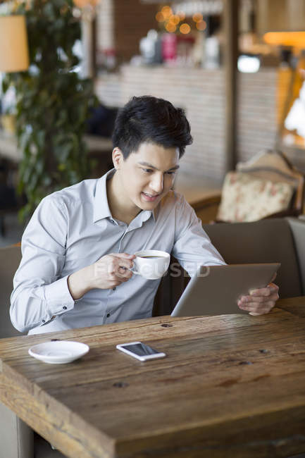 Uomo cinese che utilizza tablet digitale in caffè — Foto stock