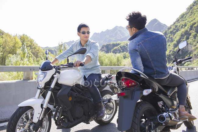 Amigos chineses sentados em motocicletas juntos — Fotografia de Stock