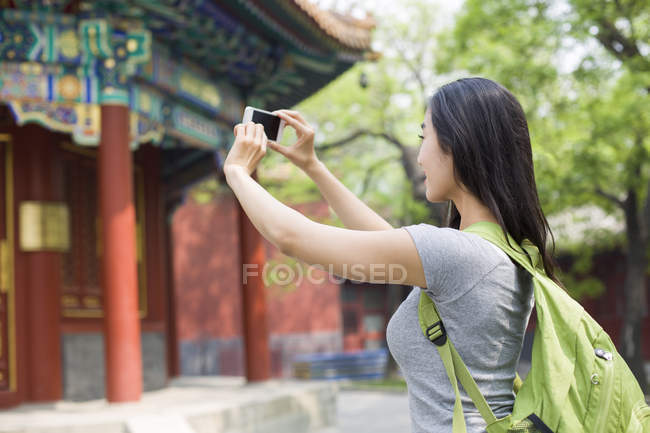 Femme chinoise prenant des photos avec smartphone au Temple Lama — Photo de stock